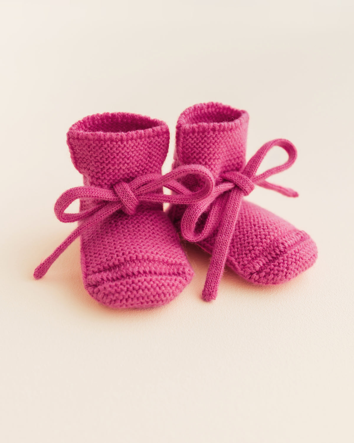 Hvid wollen babyslofjes fuchsia