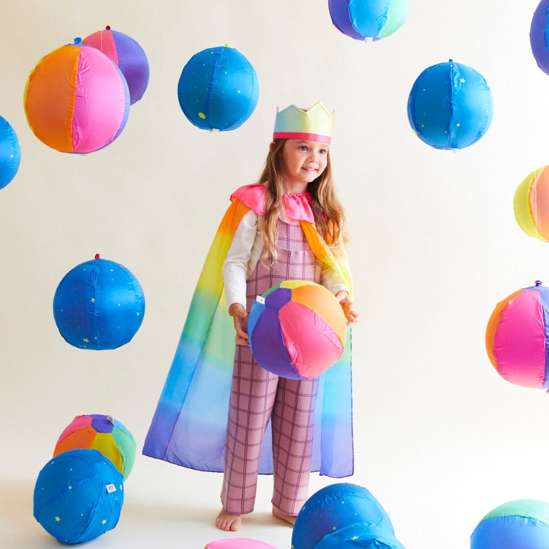 Kind speelt met veel ballonnen met ballon covers van Sarah's Silks met sterren en regenboog motief