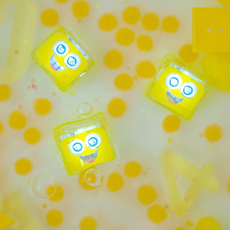 Drie Lichtgevende blokjes van glo pals in het water met meer gele versieringen