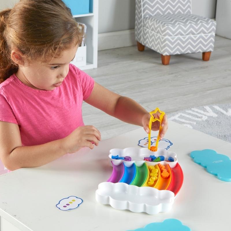 Kind pakt figuurtje uit de regenboog met een tang