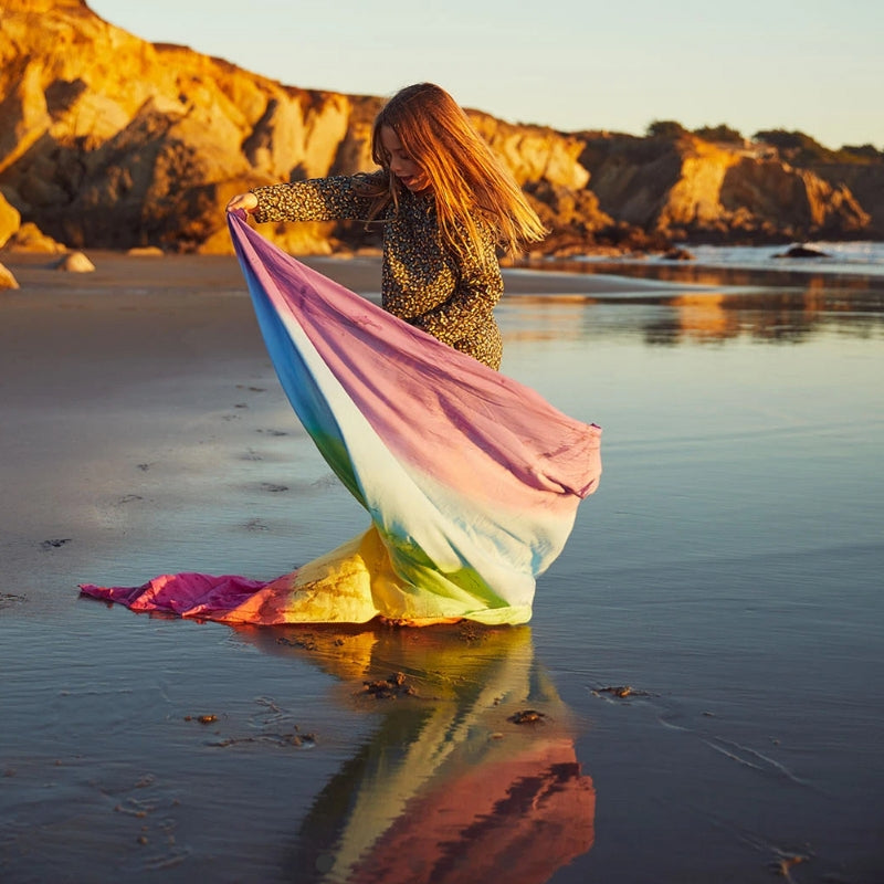 Kind speelt met de speeldoek op het strand