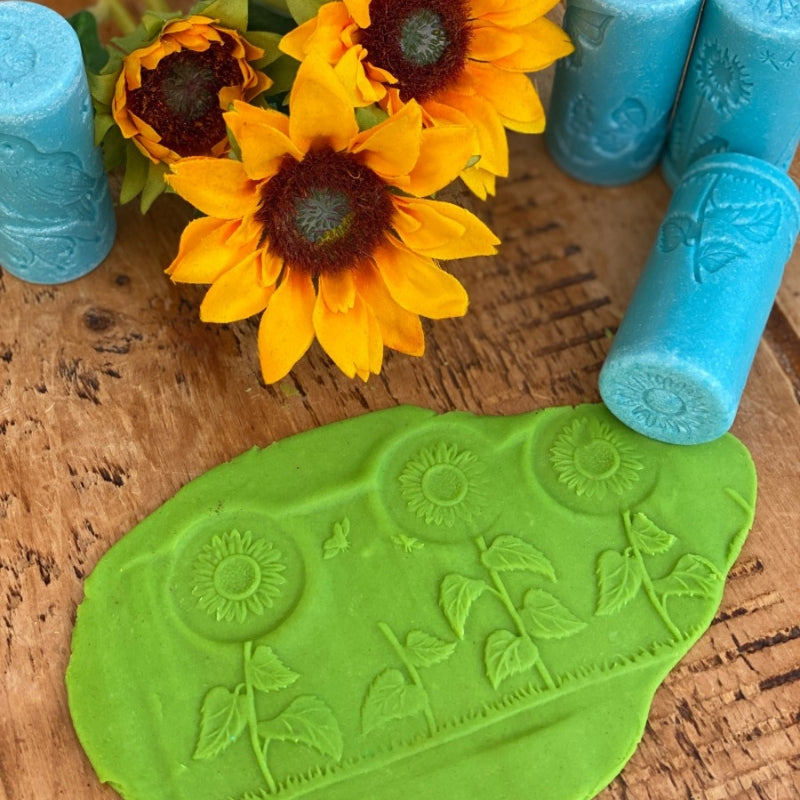 Groene klei waar een patroon met zonnebloemen in gerold is. 