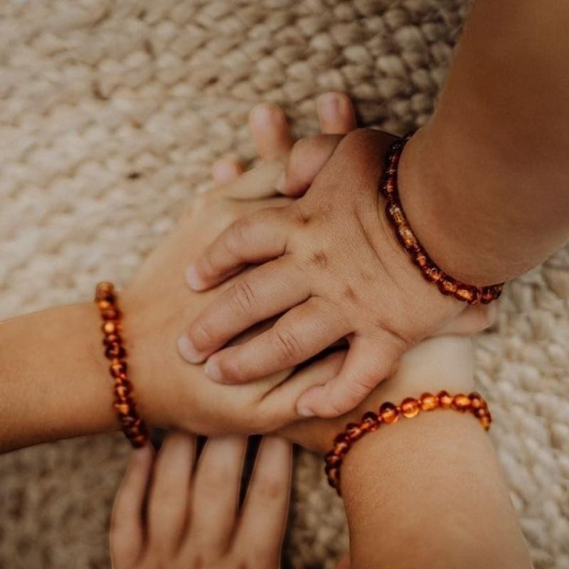 Kinder Wonderland cognac barnsteen armbandjes voor baby en peuter gedragen om de polsjes