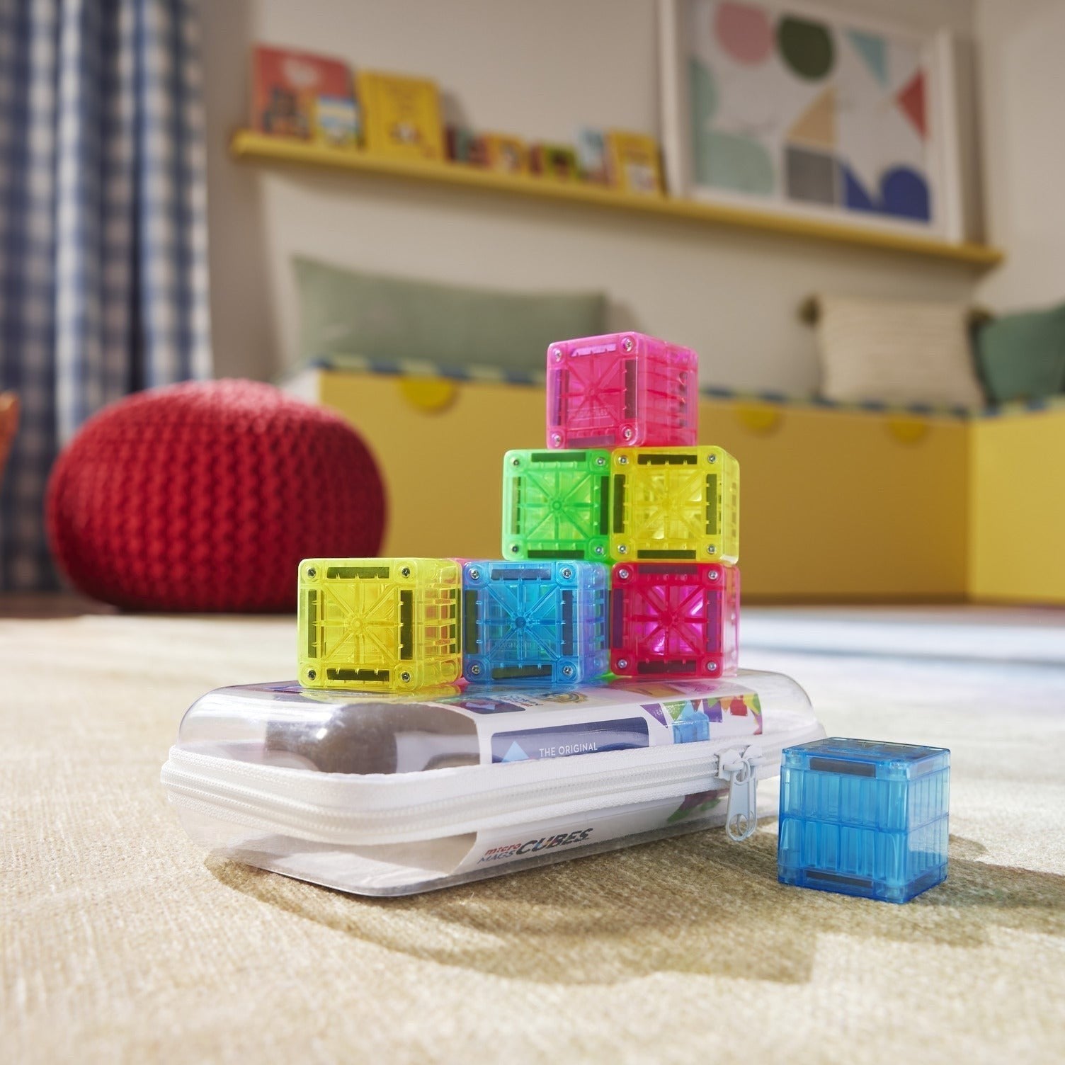 Kinder Wonderland Magna-Tiles Cubes in diverse kleuren gestapeld op een doorzichtige etui in een kinderkamer